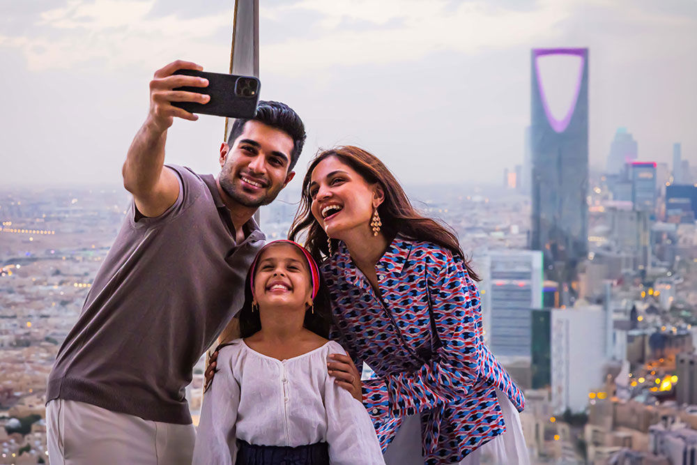 Family takes a photo in front of the Riyadh city from a view